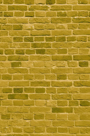 Yellow brick wall with textured surface and varied brick tones creating a visually appealing background for design and architecture applications.の写真素材