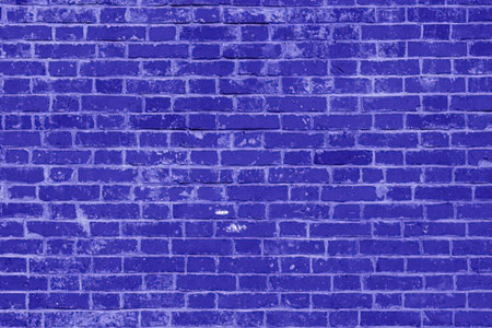 Navy blue brick wall with weathered surface and white speckles creating a textured background for...