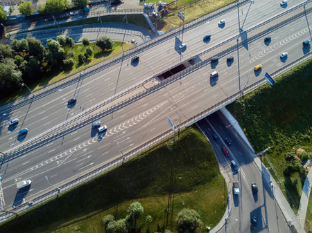 Multiple lanes of traffic flow through a modern highway system with cars and trucks moving on the...