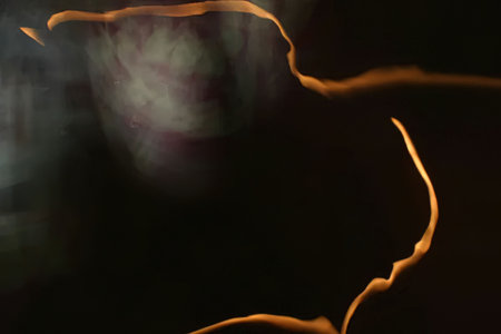 Glowing orange electric arc and sparks in a dark environment with abstract blurry background,...