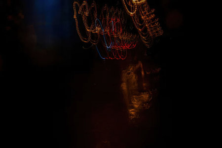 Man taking a self portrait photo using camera light trails in the dark with a slow shutter speed...
