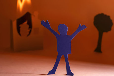 Paper cutout person stands happily with arms raised in a joyful celebratory gesture against an...