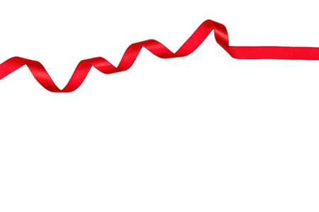 Red satin ribbon curled and wavy across the top on a white background for decoration and gift...