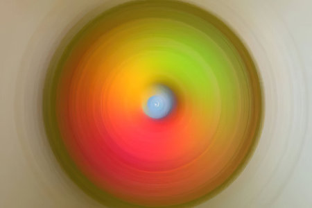 Colorful abstract circular pattern blurs into motion creating a dynamic visual effect with swirling...