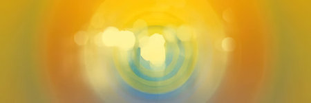 Swirling yellow, blue, and orange colors blend together creating a vibrant abstract background with a dynamic visual effect and blurred bokeh lights in the center.の写真素材