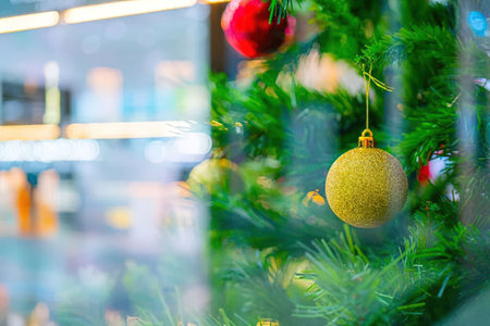 Christmas tree decorated with colorful ornaments and baubles is beautifully displayed in a store...