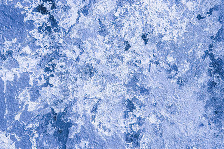 Blue textured background featuring a rough surface and abstract white pattern creating a unique...