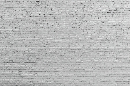White painted brick wall texture background providing a clean and neutral surface for design and...