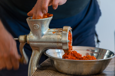 A white Caucasian man is grinding paprika for delicious traditional Serbian meal called Ajvar