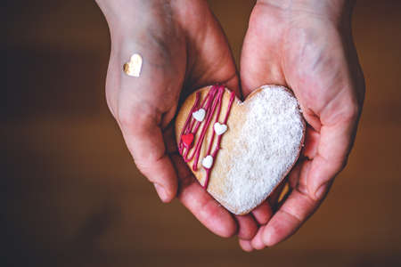 Woman in red shirt holds heart cake in hands, Symbol of love givingの写真素材