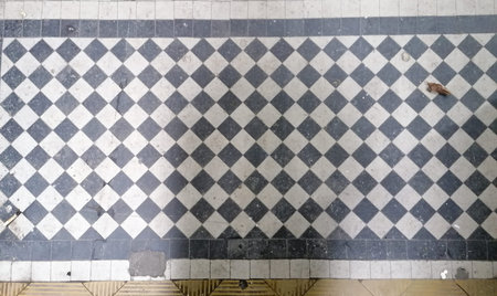 Old black and white checkered floor tiles. Texture background.