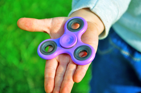 Child holds the spinner in his handの写真素材