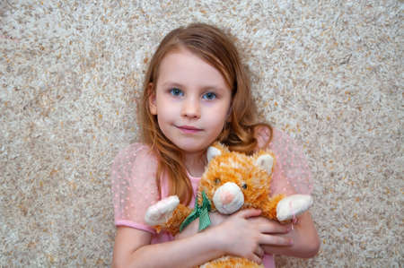 Girl with a soft toy rejoices and laughs.の写真素材
