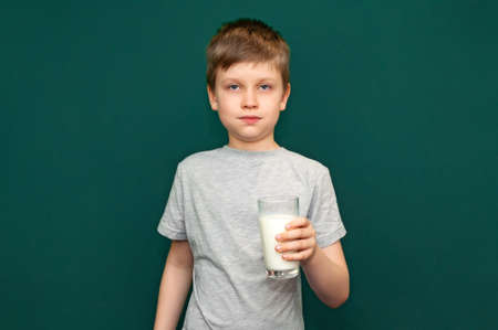Boy child holding a glass of milk in her handsの写真素材