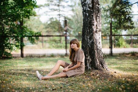 young beautiful girl in dress posing in the parkの写真素材