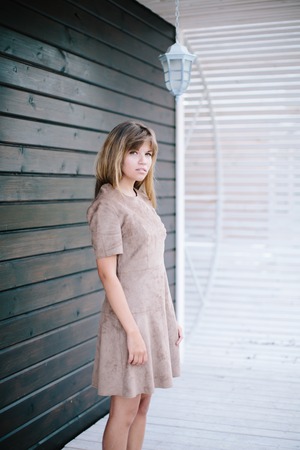 beautiful girl posing on a background of a wooden wallの写真素材