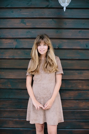 beautiful girl posing on a background of a wooden wallの写真素材