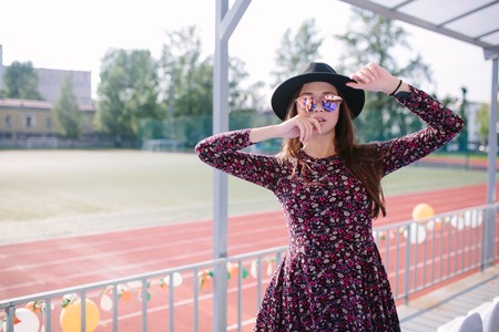 Beautiful girl in dress posing in the stadiumの写真素材