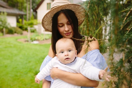 Young mother with newborn baby on the grass
