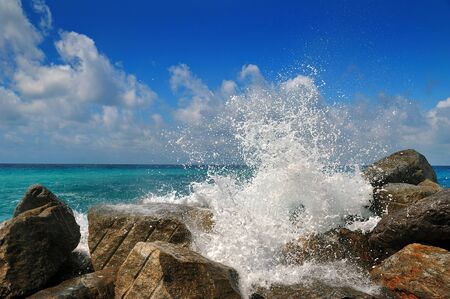 Powerful sea wave is split about stone of splashesの写真素材