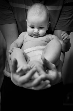 little baby in the arms of dad black and whiteの写真素材