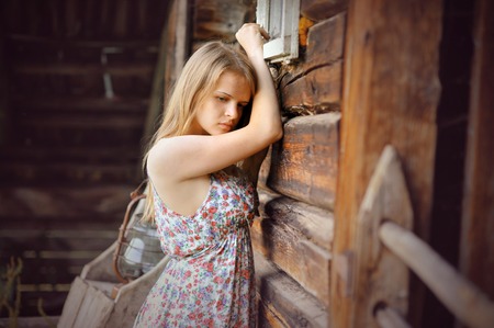 romantic sad girl near rustic wooden wallの写真素材