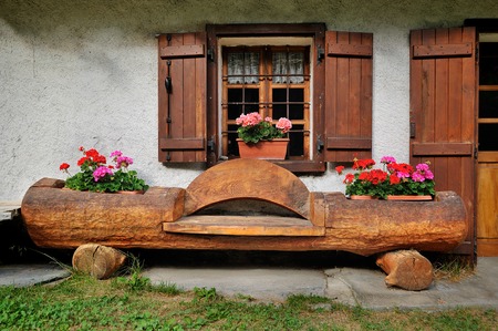 Alpine traditional facade house with bench, landscape designの写真素材