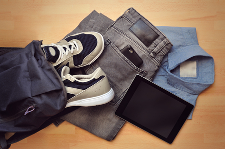 Flat lifestyle colection of mans clothes with gadgets on wooden backgroundの写真素材