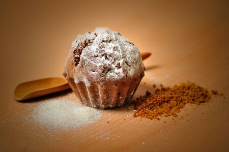 sweet cupcake with sugar on wooden cochleare and board backgroundの写真素材