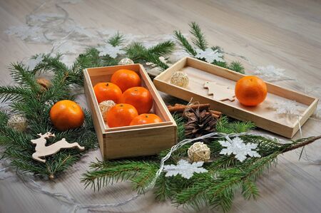 Christmas composition with tangerines in a wooden box and garlandsの写真素材