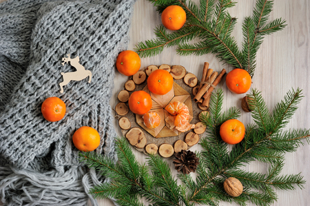Tangerines slices, scarf and spruce branches on a wooden tableの写真素材