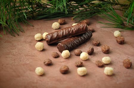 chocolate on the brown surface with branches of pine needles