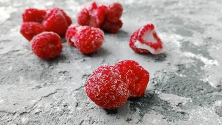 frozen raspberries on cold, frost grey concrete surfaceの写真素材