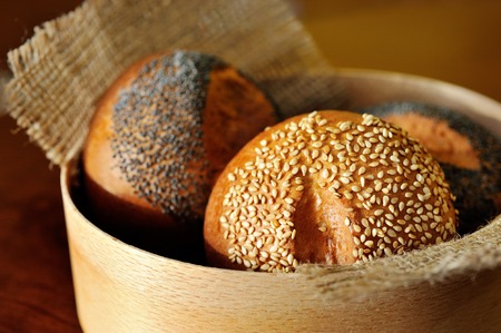 focus on buns with sesame and poppy in basketの写真素材