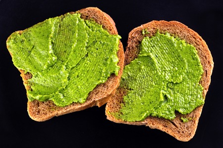 bread with fresh basil pesto on blackの写真素材