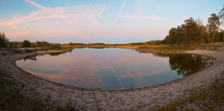 Lake with sandy shore panoramic view on evening pink light, Ukraine