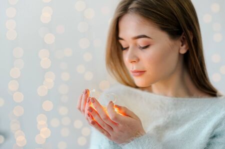 a pretty girl with Garland in hands, beautifully decorated New Year's house, looks away and smiles.の写真素材