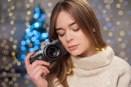 Beautiful girl celebrating New Year. Garlands, bokeh. Old photo shot on film camera.の写真素材