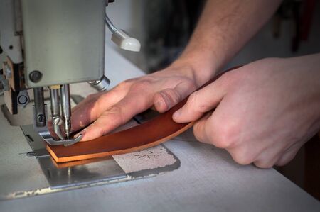 Close up of a leather master sewing leather bag