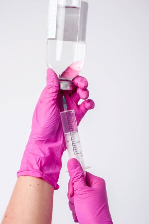 The nurse prepares for the medical procedure by filling the syringeの写真素材