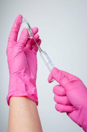 The nurse prepares for the medical procedure by filling the syringeの写真素材