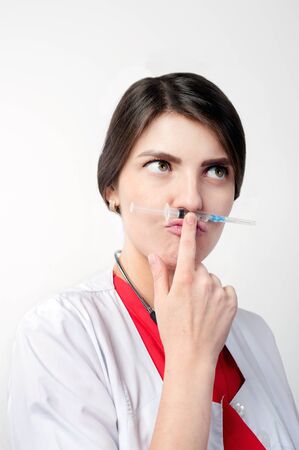 portrait of medical worker joking with syringeの写真素材