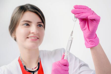 The nurse prepares for the medical procedure by filling the syringeの写真素材