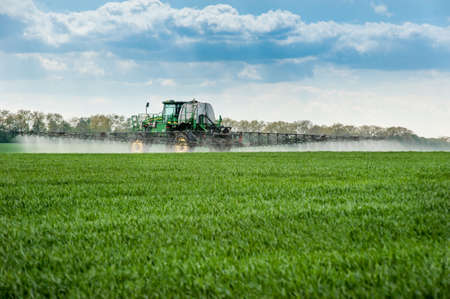 Velykyi Hlybochok, Ternopil, Ukraine - May 8, 2020. Sprayer fertilizes with fertilizers, rear view, fertilizers on agricultural green fields in the spring, Ukraine.のeditorial素材