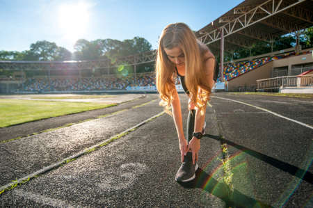 young sportswoman girl doing morning sports exercises, direct sunlightの写真素材