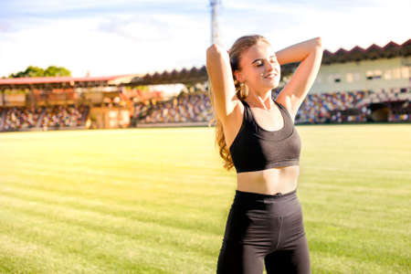 morning sports exercises of young sportswoman at stadium