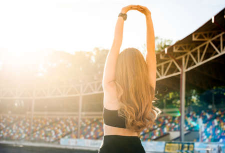 girl doing morning sports exercises stretching in the morning at dawnthe back, direct sunlightの写真素材
