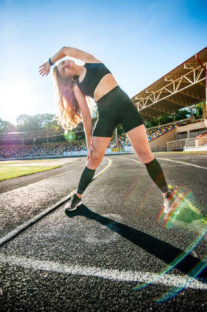young girl doing morning sports exercises stretching in the morning at dawnの写真素材