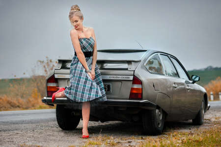 beautiful blonde woman walking near a retro car near a lavender field in the French style