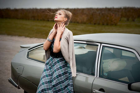 Young beautiful woman walking near the retro car near lavander field at french styleのeditorial素材